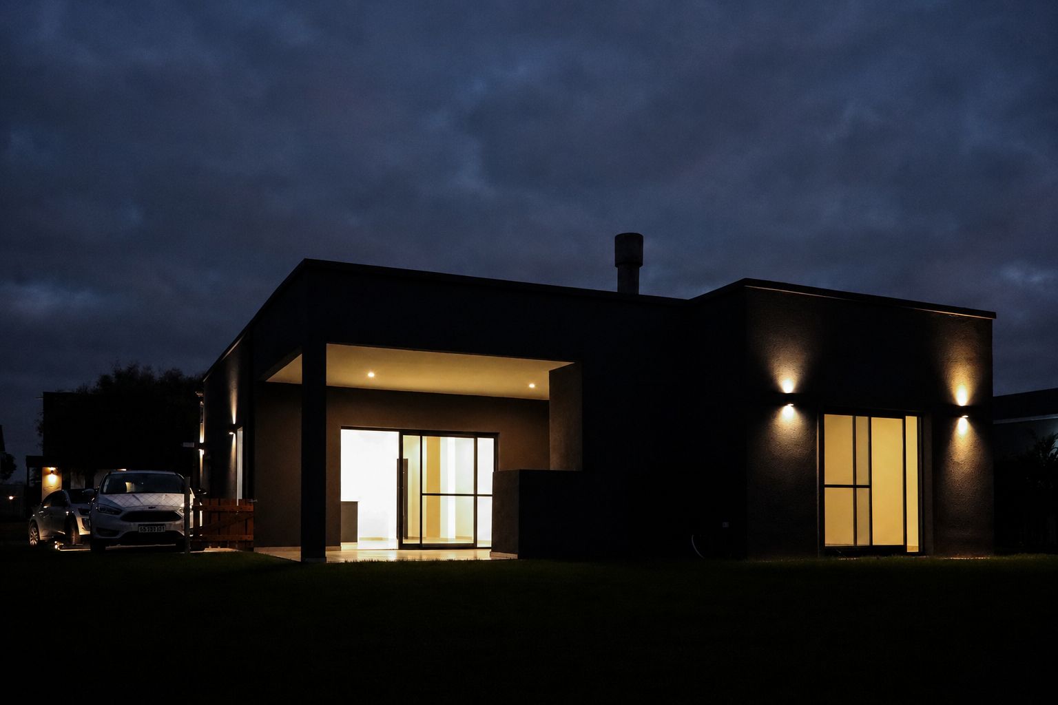 Fachada trasera iluminada de una casa FN de noche